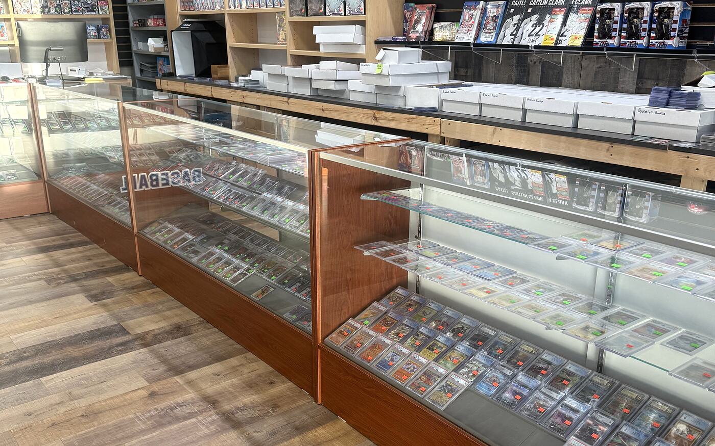 Two glass showcase runs at the Kearney shop, both filled with price-tagged graded slabs standing in rows.